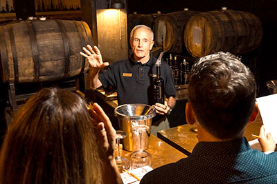 Man pouring wine for a couple at a wine bar